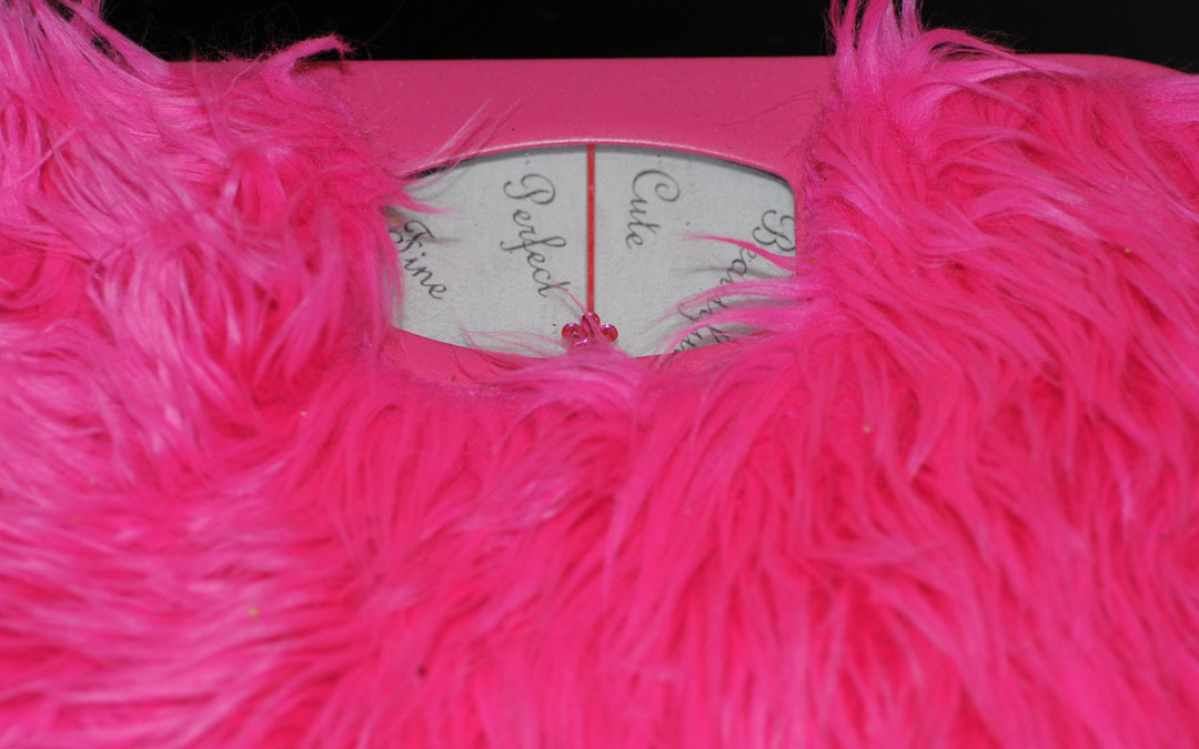 Image of hot pink feathered bathroom scale that says things like "cute" or "perfect" instead of showing numbers